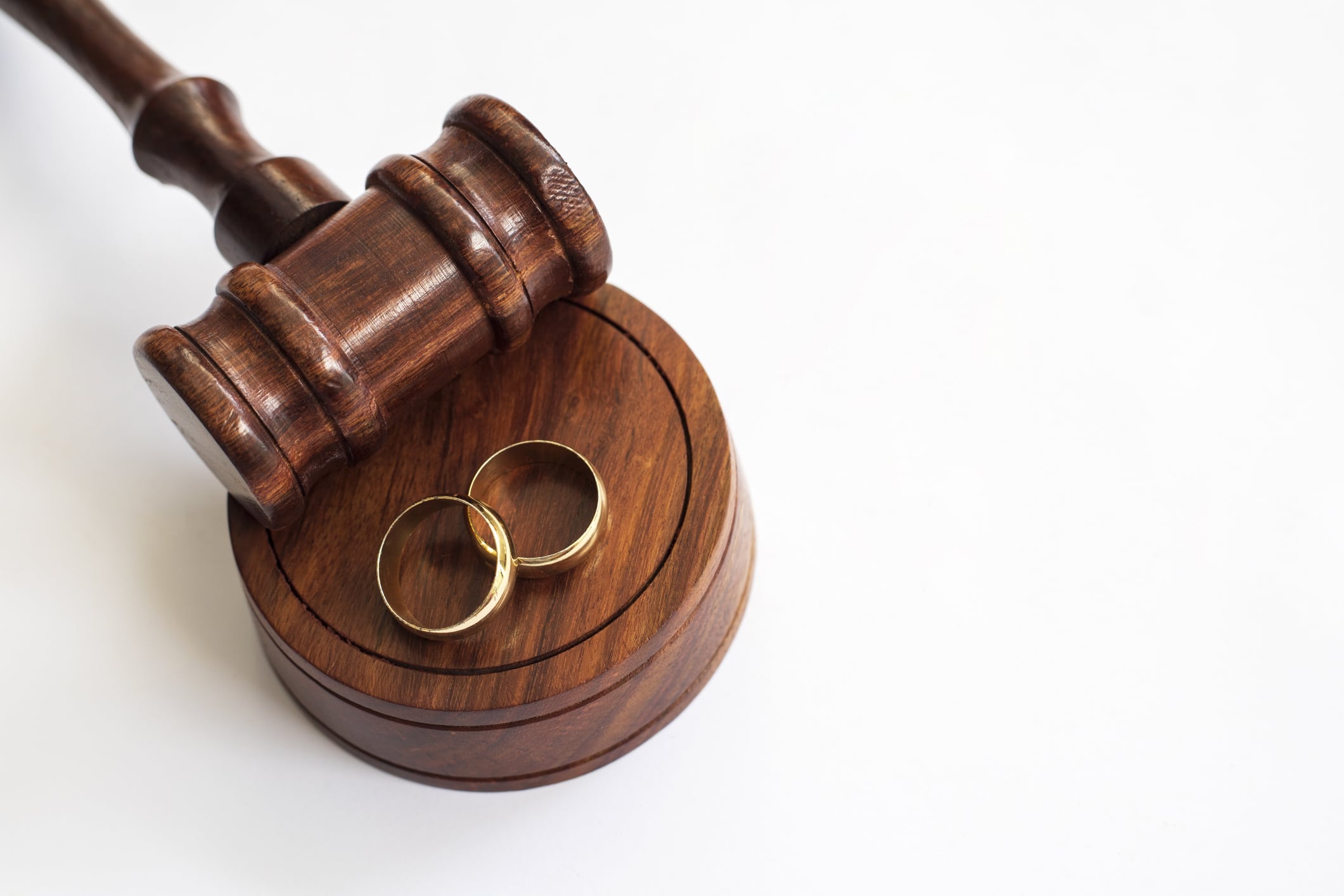 Wooden gavel and wedding rings on white background Directly above