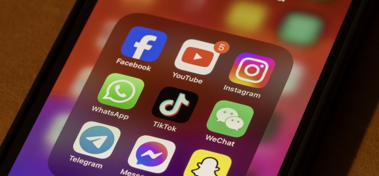 Smartphone screen showing a 'Social Media' folder with icons for Facebook, YouTube, Instagram, WhatsApp, TikTok, WeChat, Telegram, Messenger and Snapchat in a colorful grid.