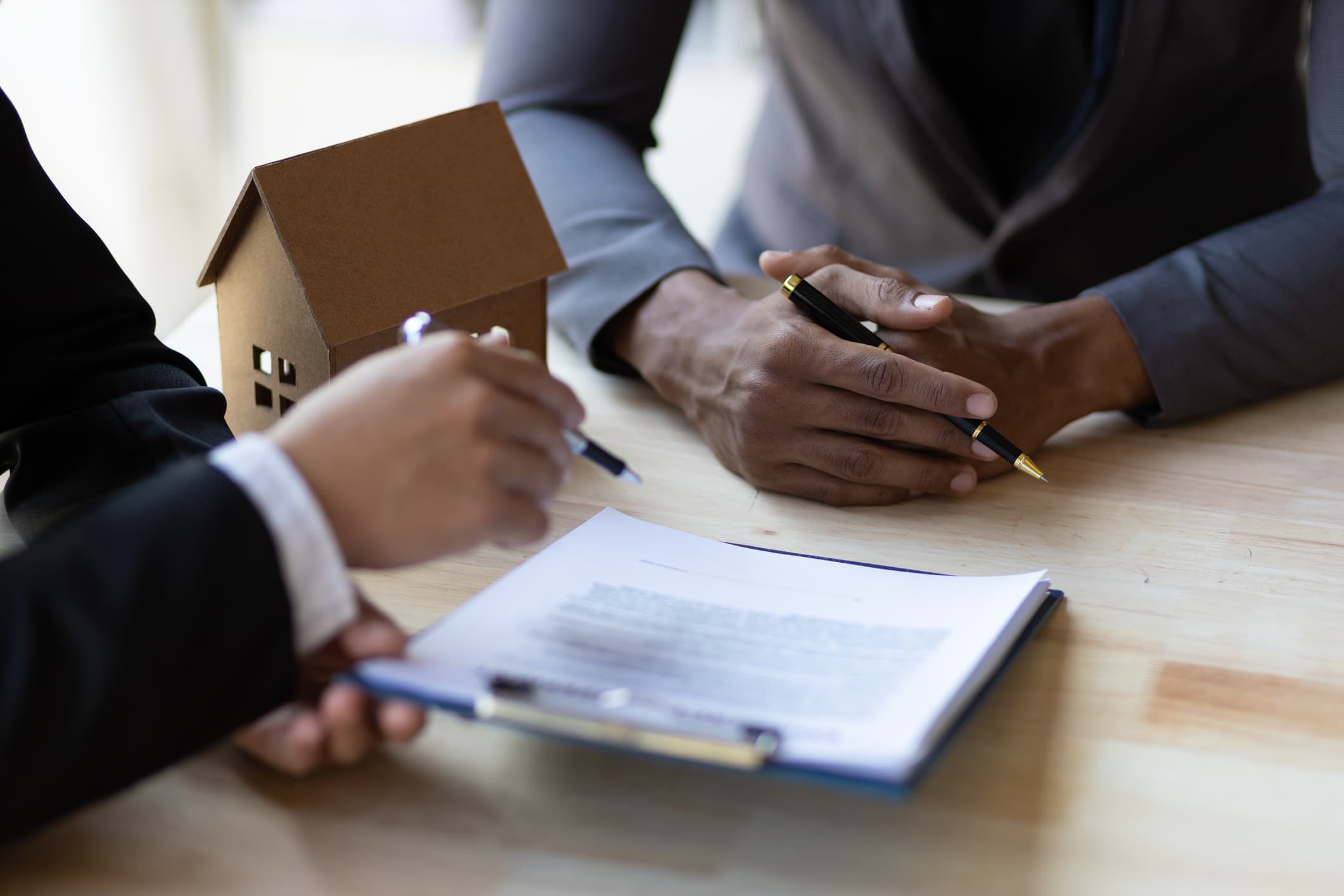 Businessmen and real estate agents discussing documents signing a legal purchase of a house
