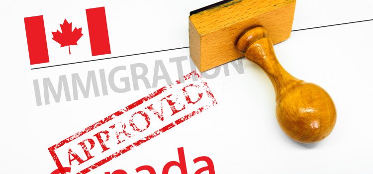 Canada immigration approval stamp on an official document with a wooden gavel nearby, symbolizing approval and law/decision making
