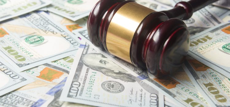 Gavel resting on scattered US $100 bills, conveying money and justice.