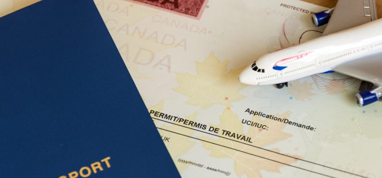 Blue Canadian passport rests on a travel document with a map background and a toy airplane nearby.